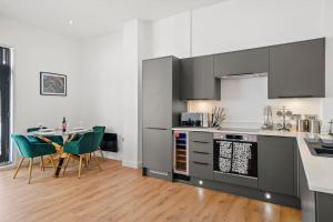 een keuken met een tafel en stoelen in een kamer bij Luxury Split Level 2 Bed Apartment in Ramsgate