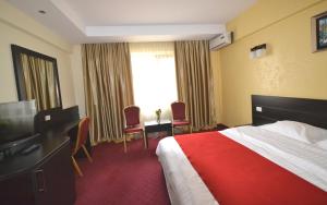 een hotelkamer met een bed en een televisie bij Hotel Ancor in Boekarest