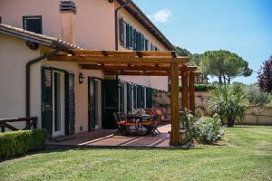 a wooden pergola with a table and chairs on a patio at Tenuta Santa Cristina in Magliano Sabina