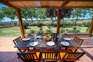 a wooden table with chairs on a patio at Tenuta Santa Cristina in Magliano Sabina