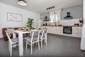 una cucina bianca con tavolo e sedie bianchi di Apartment Bo&Dy a Ražanj