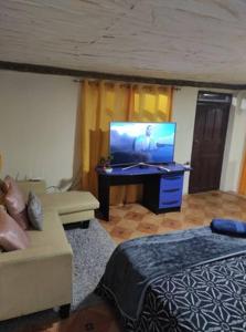 salon z telewizorem i kanapą w obiekcie Casa Confortable en Zamora Chinchipe w mieście Zamora