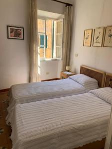 two beds in a bedroom with a window at Via Scappini in Rio Marina
