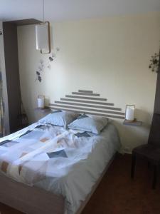 a bedroom with a large bed and a chair at La Perline, Maison individuelle - 4 à 6 personnes in Le Crestet