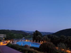 Blick auf ein Schwimmbad bei Nacht in der Unterkunft Glamping Le Tegole in Riparbella