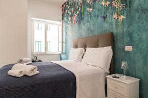 een slaapkamer met een bed met een blauwe muur bij Relais Vittorio Veneto - Luxotel & Apartotel in Salerno