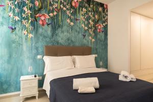 1 dormitorio con 1 cama grande y papel pintado con motivos florales en Relais Vittorio Veneto - Luxotel & Apartotel, en Salerno