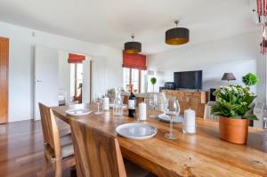 uma sala de jantar com uma mesa de madeira e copos de vinho em Sea Towers Apartament 27 z Tarasem em Gdynia