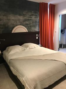 1 dormitorio con 1 cama grande y cortina roja en Logis Hôtel Altitude et Spa Pierre-Percée, en Pierre-Percée