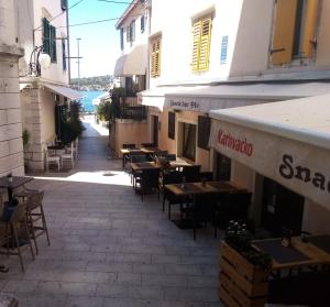 una calle vacía con mesas y sillas en un edificio en Guesthouse Merla, en Šibenik