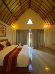 een slaapkamer met een groot bed in een kamer bij The Dulu Penida Cottage in Nusa Penida
