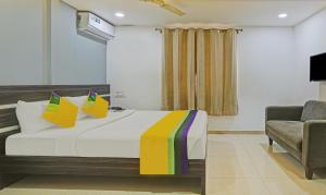 a hotel room with a bed and a chair at Itsy Hotels Purple Suites in Bengaluru