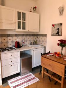 a kitchen with white cabinets and a table at LeopardElla in Rome