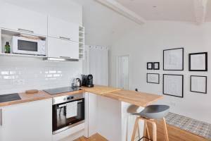 - une cuisine blanche avec un comptoir et un four micro-ondes dans l'établissement Le Cosy Spa & Office au cœur de Toulouse, à Toulouse