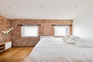 - une chambre avec un grand lit et un mur en briques dans l'établissement Le Cosy Spa & Office au cœur de Toulouse, à Toulouse