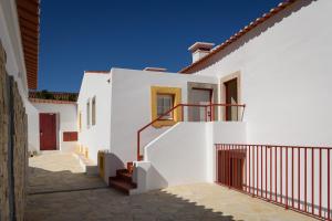 Biały dom ze schodami i niebieskim niebem w obiekcie Casa Lidador - Obidos w mieście Óbidos