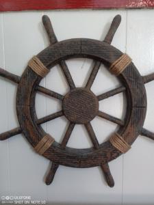a wooden steering wheel hanging on a wall at Snowdon House Single rooms for solo travellers in Rhyl