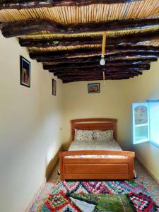 een slaapkamer met een bed en een houten plafond bij GITE TAGMA in Berkane