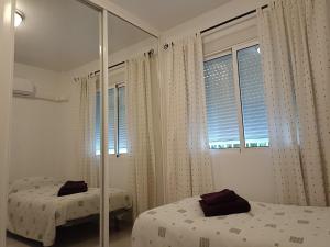una camera da letto con due letti e una finestra di MAISON ENTIERE AVEC PISCINE, WIFI, GRAND SOLARIUM ET TERRAIN ARBORE a Orihuela Altre 17 foto