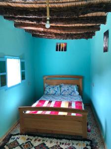 貝爾坎的住宿－GITE TAGMA，一间设有一张蓝色墙壁床铺的卧室
