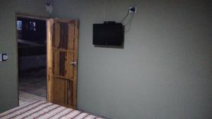 a room with a door and a television on the wall at Hotel Bates in Villa General Belgrano