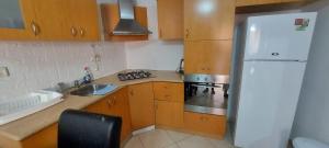 a kitchen with a refrigerator and a stove top oven at Apartment Amdar Village עם ממ"ד in Eilat +8 photos