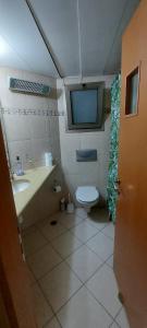 a bathroom with a sink and a toilet and a tv at Apartment Amdar Village עם ממ"ד in Eilat