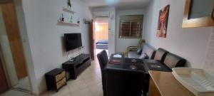 a living room with a table and chairs and a television at Apartment Amdar Village עם ממ"ד in Eilat