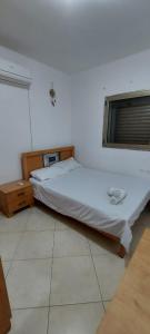 a bedroom with two beds and a window at Apartment Amdar Village עם ממ"ד in Eilat