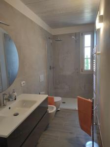 bagno con lavandino, servizi igienici e specchio di Affittacamere Villa Mary a Pistoia