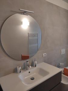 bagno con lavandino bianco e specchio di Affittacamere Villa Mary a Pistoia