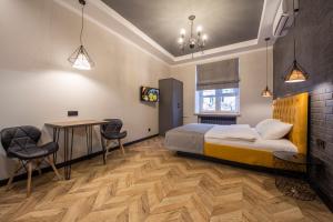 a bedroom with a bed and a table and chairs at Idea Design Apart-Hotel Prorizna in Kyiv