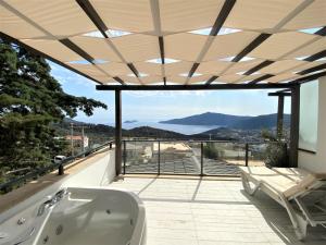 a bath tub on a balcony with a view at Sultan Hotel Kalkan in Kalkan