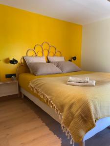 瑟寒河畔諾耶的住宿－Logement entier Noyers - L'Appart des Anges 2，一间卧室设有一张黄色墙壁的大床