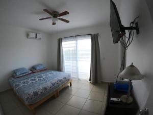 ein Schlafzimmer mit einem Bett und einem Deckenventilator in der Unterkunft Casa Coral 4 habitaciones in Puerto Morelos + 23 Fotos