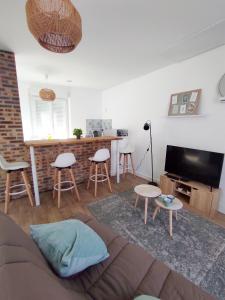 a living room with a couch and a table at Les Nuits Bonneuilloises Le Percheron in Breteuil