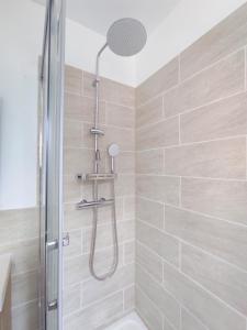 a shower with a glass door in a bathroom at Les Nuits Bonneuilloises Le Percheron in Breteuil