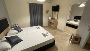 una camera d'albergo con due letti e uno specchio di Ionian Boutique Apartments ad Agios Georgios
