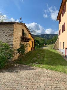 a brick road next to a building with a grass yard at Le Mulina in Barberino di Mugello