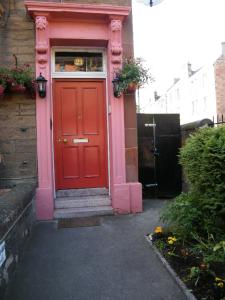 a red door on a house with a window at Badjao B&B in Edinburgh