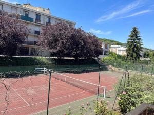 einen Tennisplatz vor einem Gebäude in der Unterkunft STUDIO PROCHE PARIS VERSAILLES in Villennes-sur-Seine