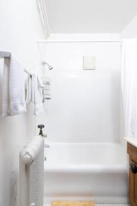 y baño blanco con bañera, ducha y toallas. en Flexhome Economy 1BR Apartment B4 - READ INFO en Milwaukee