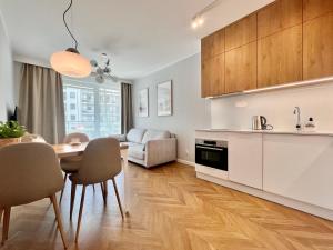 a kitchen and living room with a table and chairs at Angielska Grobla Old Town by Q4Apartments in Gdańsk