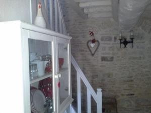una escalera con un armario blanco en una habitación en MANOIR de la RIVIERE, en Géfosse-Fontenay