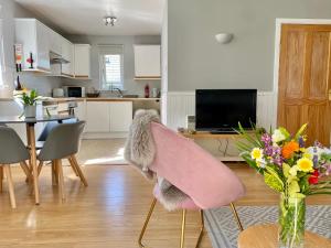 a living room with a chair with a vase of flowers at Homestead Cottage, Fort Augustus in Fort Augustus +12 photos