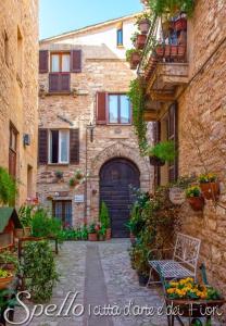 a stone building with a door in a courtyard at Nel vicolo dei Baci - Casa vacanze al Bacio in Spello +82 photos