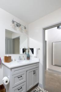 een badkamer met een witte wastafel en een spiegel bij Flexhome Brewery District 2BR Apt M11 - READ INFO in Milwaukee