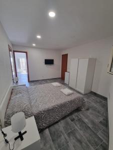 a bedroom with a bed and a desk and a tv at B&B lapigna in Caltagirone