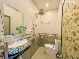 a bathroom with a sink and a toilet and a tub at Homestay Qhome in Con Dao