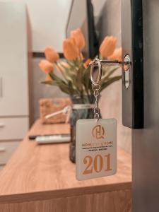a key tag on a kitchen counter with a vase of orange roses at Homestay Qhome in Con Dao